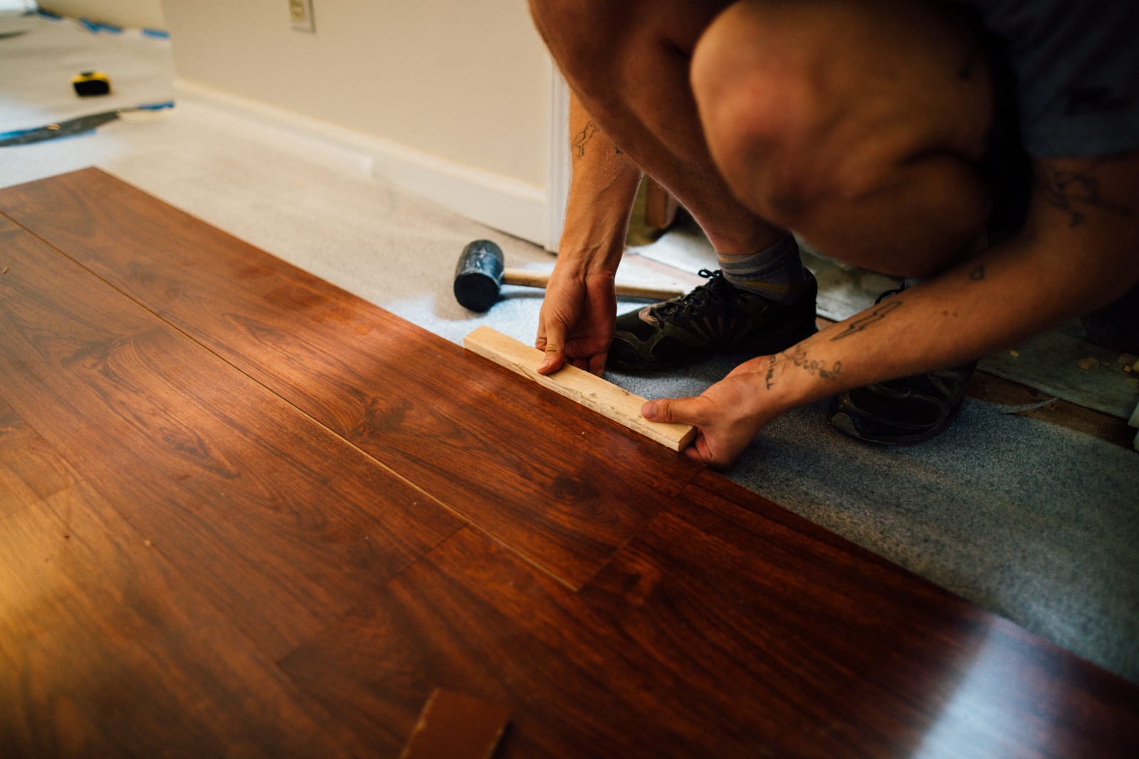 Craftsman precisely setting natural oak herringbone parquet planks during installation