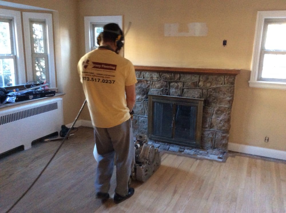 Craftsman sanding a hardwood floor with a dustless machine